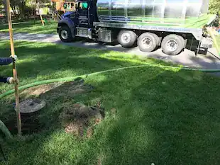 Professional drain cleaning truck working on outdoor drain system.